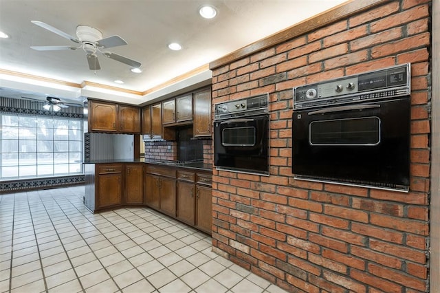 kitchen featuring black appliances, light tile patterned floors, and crown molding