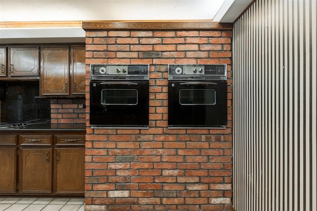 kitchen with black appliances, light tile patterned flooring, and dark brown cabinetry