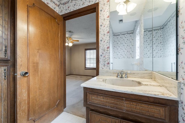 bathroom featuring ceiling fan, tile patterned flooring, vanity, and a textured ceiling