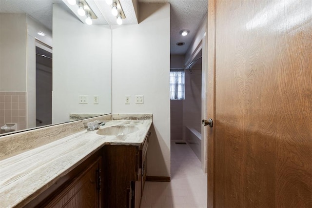 bathroom with tile patterned floors, vanity, and a textured ceiling