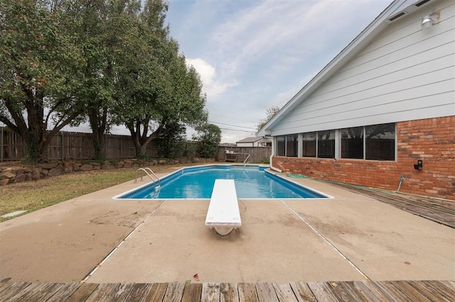 view of pool featuring a diving board and a patio