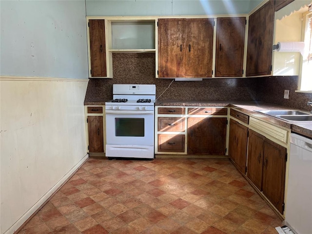 kitchen with backsplash, sink, and white appliances