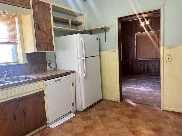 kitchen featuring backsplash, white appliances, and sink