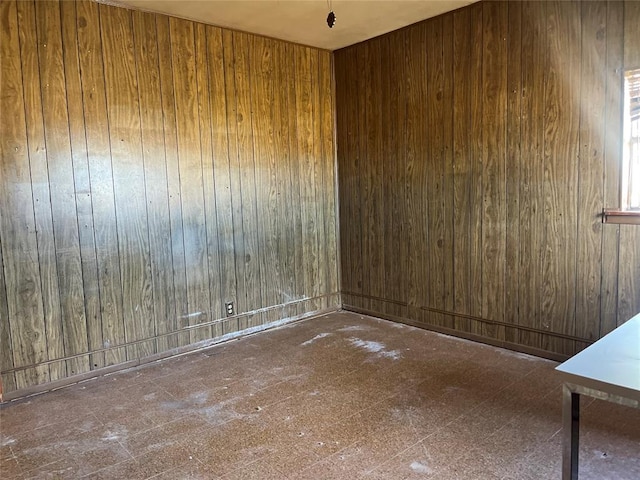 unfurnished room with wood walls