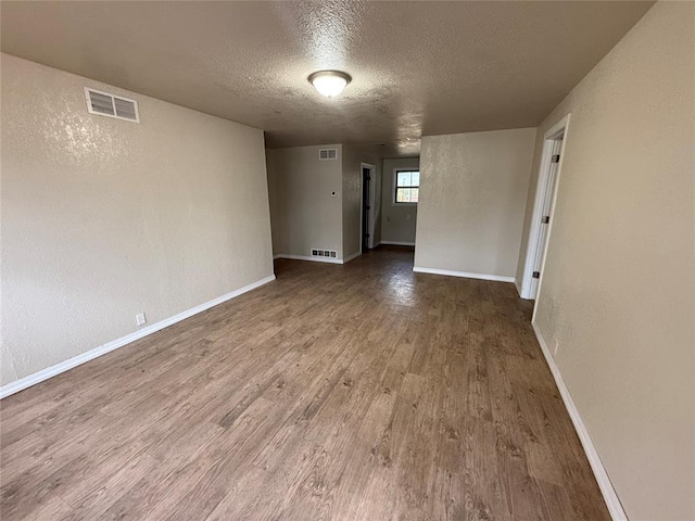 spare room with wood-type flooring and a textured ceiling