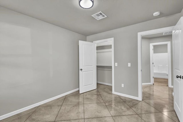 unfurnished bedroom featuring light tile patterned floors and a closet