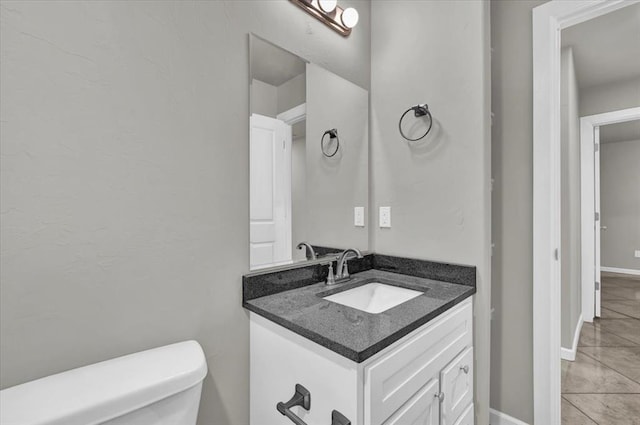 bathroom with tile patterned flooring, vanity, and toilet