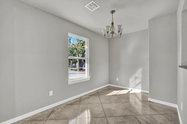 empty room featuring tile patterned floors and a notable chandelier