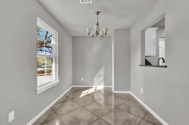 unfurnished dining area featuring tile patterned floors, sink, and an inviting chandelier