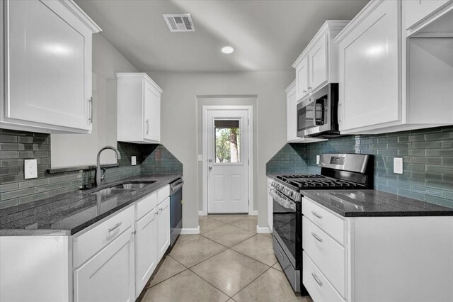 1200 N Lloyd Dr, Oklahoma City, OK 73130 - kitchen featuring stainless steel appliances, a sink, light tile patterned floors, baseboards, and dark stone counters