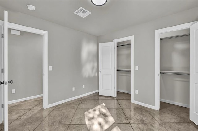 1200 N Lloyd Dr, Oklahoma City, OK 73130 - unfurnished bedroom with baseboards, multiple closets, and tile patterned flooring