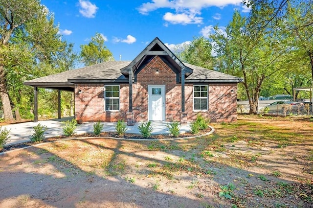 1200 N Lloyd Dr, Oklahoma City, OK 73130 - view of front facade with brick siding, concrete driveway, a carport, and a shingled roof