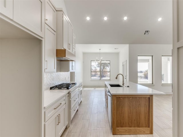 kitchen with sink, white cabinetry, and an island with sink