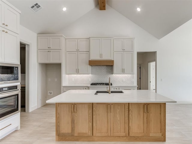 kitchen featuring sink, white cabinetry, an island with sink, and stainless steel appliances