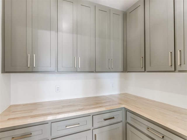 kitchen with wooden counters and gray cabinets