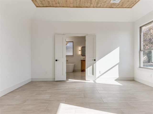 spare room with light hardwood / wood-style flooring and wooden ceiling