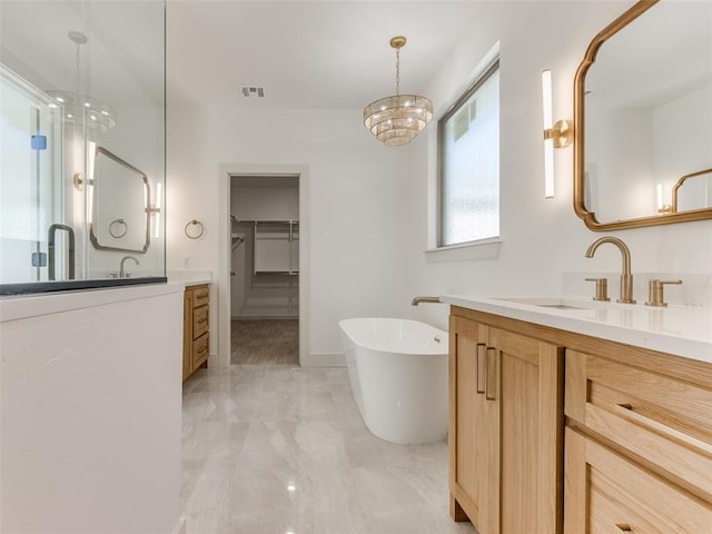 bathroom featuring a chandelier, shower with separate bathtub, and vanity