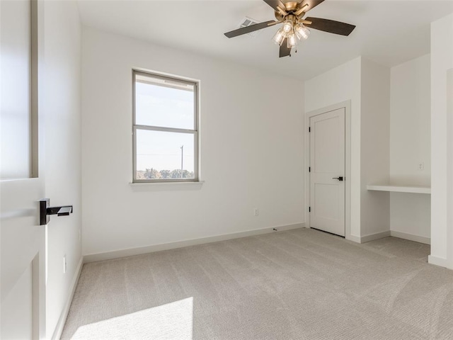 unfurnished bedroom with ceiling fan and light colored carpet