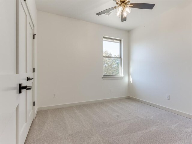 spare room featuring ceiling fan and light carpet