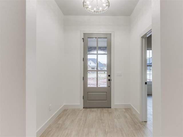 entryway with light wood-type flooring and a notable chandelier