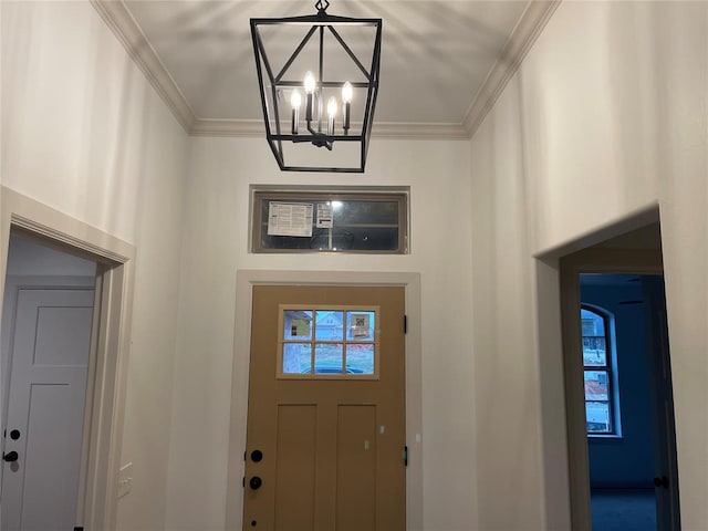 foyer featuring crown molding and a notable chandelier