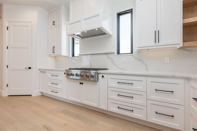 kitchen featuring stainless steel gas stovetop, a healthy amount of sunlight, light wood-type flooring, and white cabinetry