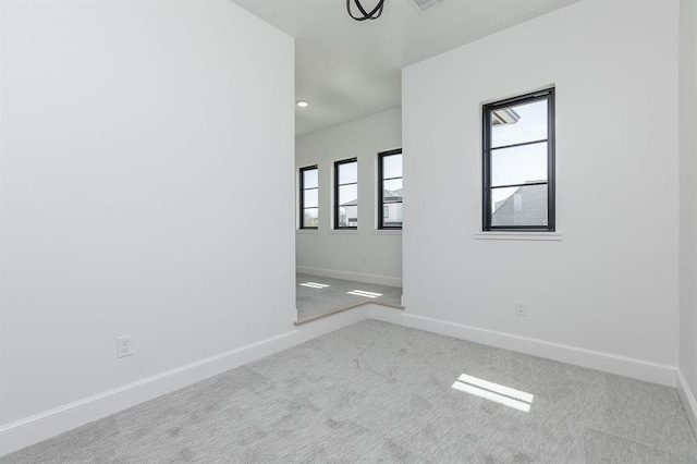 spare room featuring a healthy amount of sunlight and light carpet