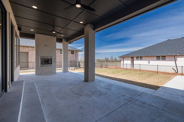 2009 Wiregrass Dr, Edmond, OK 73025 - fenced backyard with a large fireplace, ceiling fan, and a patio area