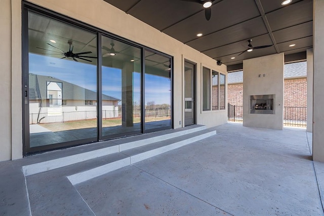 view of patio with a large fireplace and ceiling fan