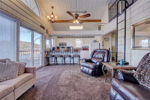 carpeted living room featuring high vaulted ceiling and ceiling fan with notable chandelier