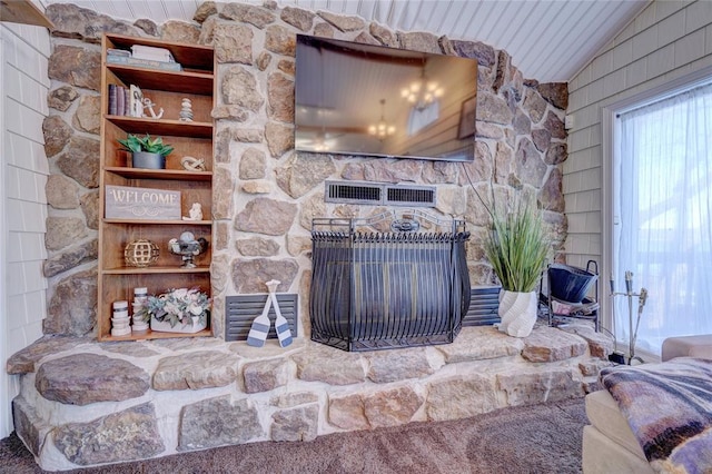 living room featuring carpet flooring, vaulted ceiling, and a stone fireplace