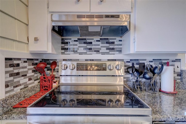 kitchen featuring decorative backsplash, light stone countertops, stainless steel electric stove, white cabinetry, and range hood