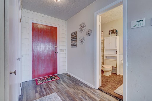 foyer entrance featuring hardwood / wood-style floors and a textured ceiling