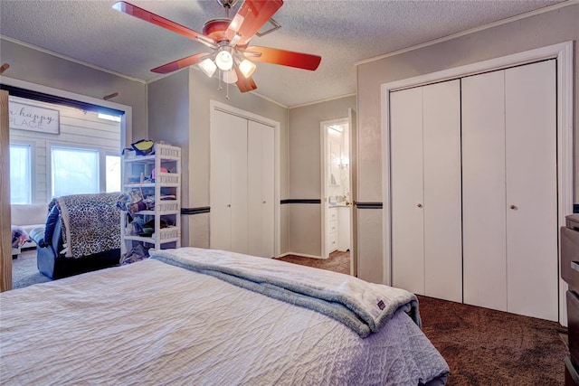 bedroom featuring a textured ceiling, carpet floors, two closets, and ceiling fan