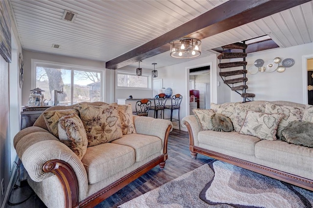 living room with beam ceiling, dark wood-type flooring, and an inviting chandelier