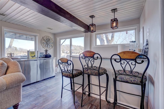 dining room featuring hardwood / wood-style floors, wood ceiling, and beam ceiling