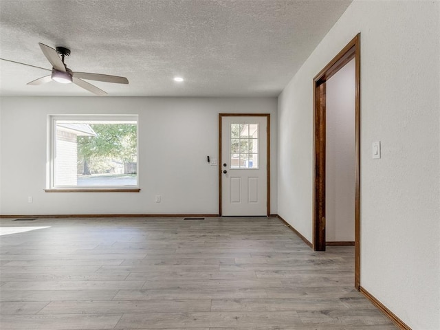 entryway featuring ceiling fan, light hardwood / wood-style flooring, and a textured ceiling