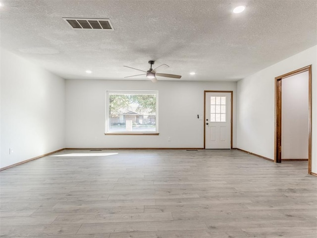 interior space featuring a textured ceiling, light wood-type flooring, and plenty of natural light