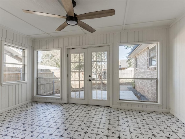 unfurnished sunroom featuring ceiling fan, a wealth of natural light, and french doors