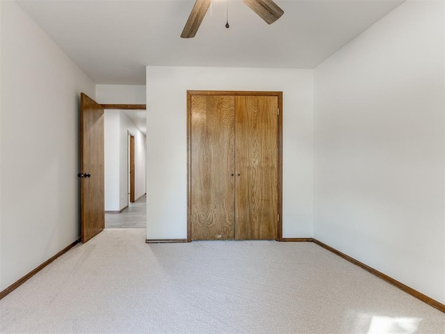 unfurnished bedroom featuring light colored carpet, a closet, and ceiling fan