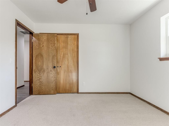 unfurnished bedroom featuring carpet flooring, ceiling fan, and a closet