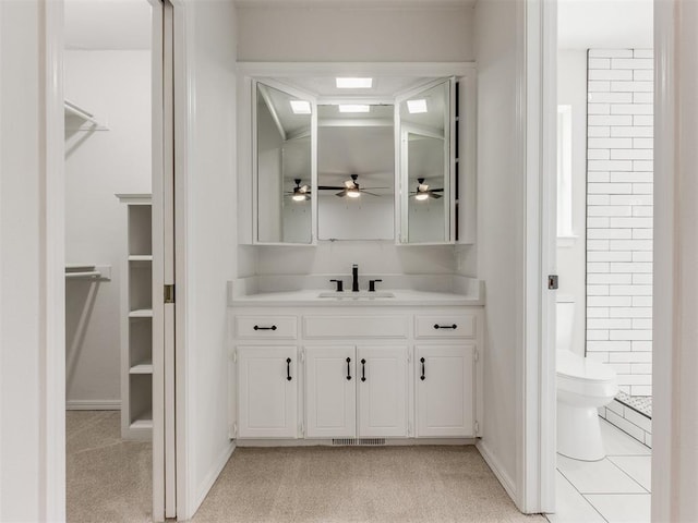 bathroom featuring tile patterned floors, ceiling fan, vanity, and toilet