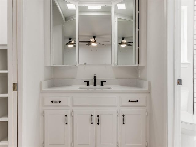 bar featuring white cabinetry, ceiling fan, and sink