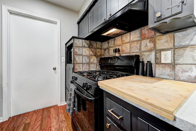 kitchen with black range with gas stovetop, dark hardwood / wood-style flooring, and backsplash