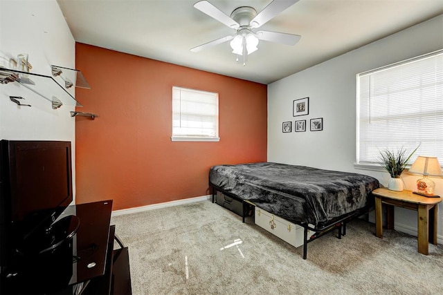 bedroom with multiple windows, ceiling fan, and light colored carpet