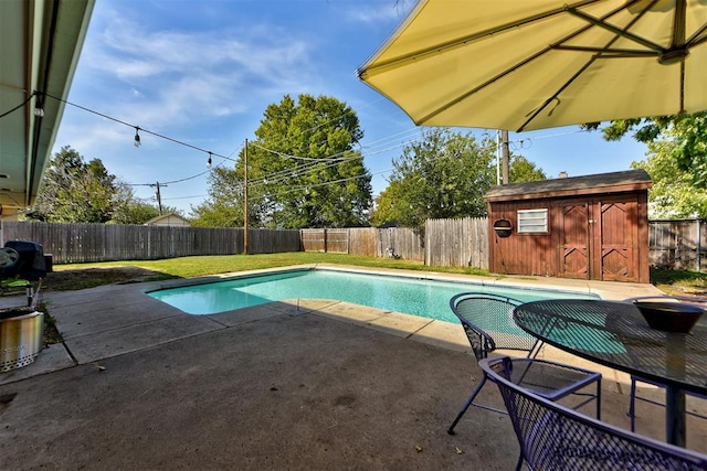 view of swimming pool with a patio and a shed