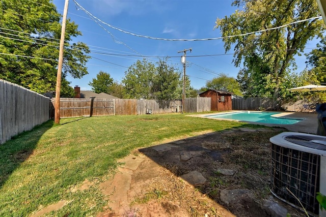 view of yard featuring a fenced in pool and central AC