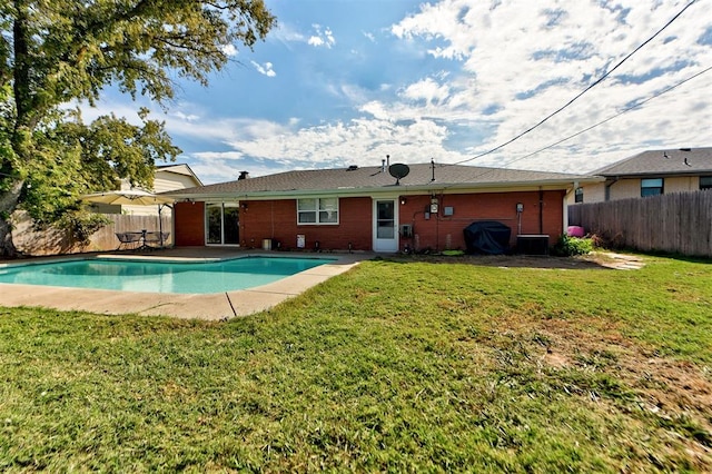 view of swimming pool featuring a yard and central AC