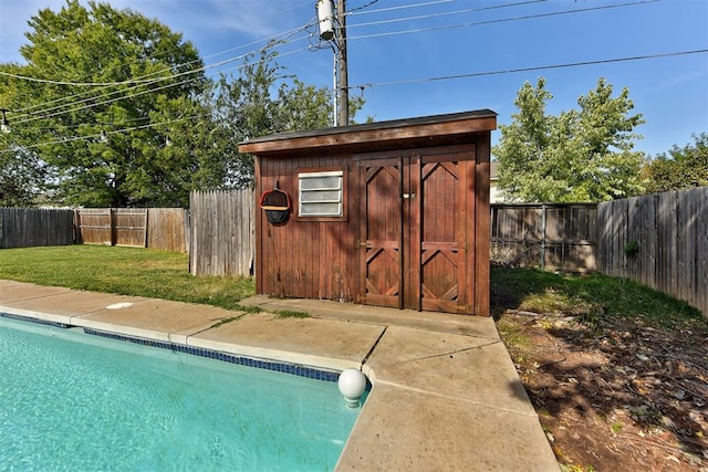 view of swimming pool featuring a storage unit and a lawn