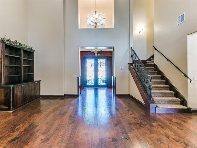 entrance foyer with wood finished floors, french doors, visible vents, and stairs